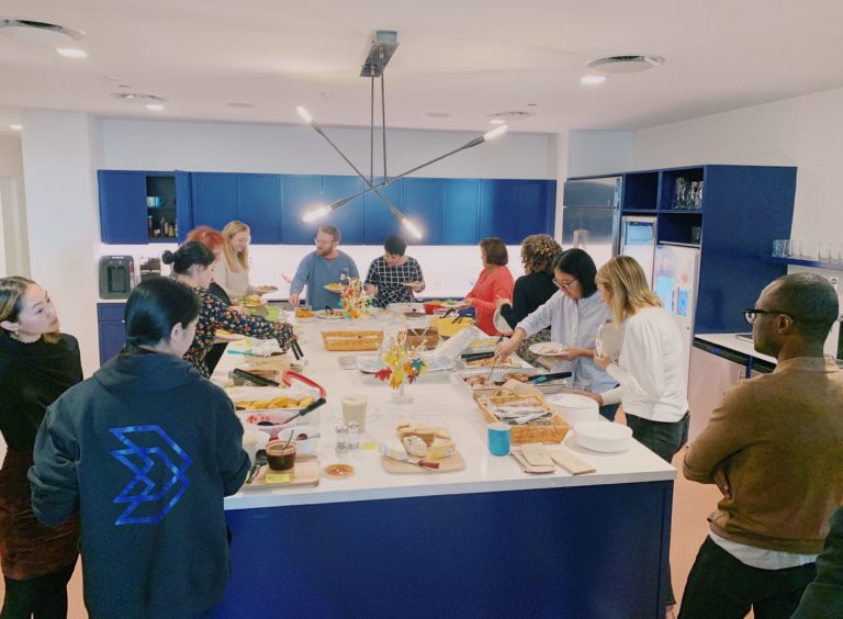 Blue State NY team gathered around a table filled with food