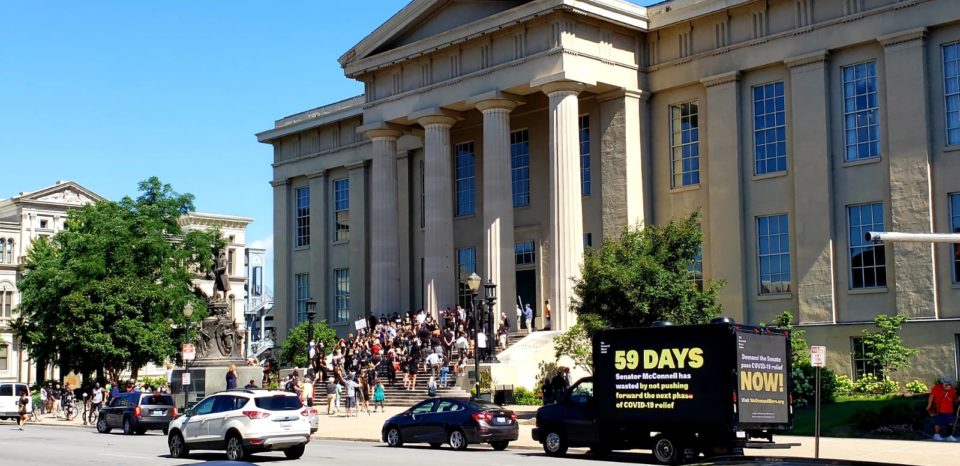 We Demand More branded van outside of government building