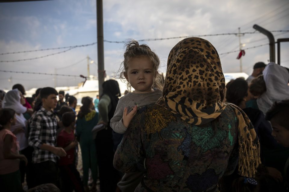 Mother holding her child, looking directly at the camera.